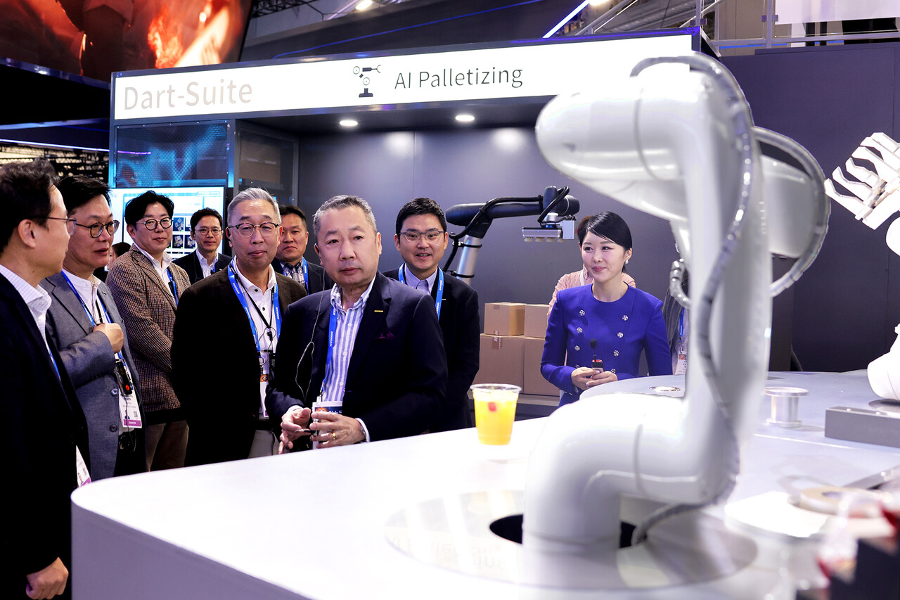 박정원 두산그룹 회장(가운데)과 박지원 그룹부회장(왼쪽)이 10일(현지시간) CES 2024가 열리는 라스베이거스컨벤션센터를 찾아 두산 부스에서 AI칵테일 로봇을 살펴보고 있다. (출처=두산그룹)
