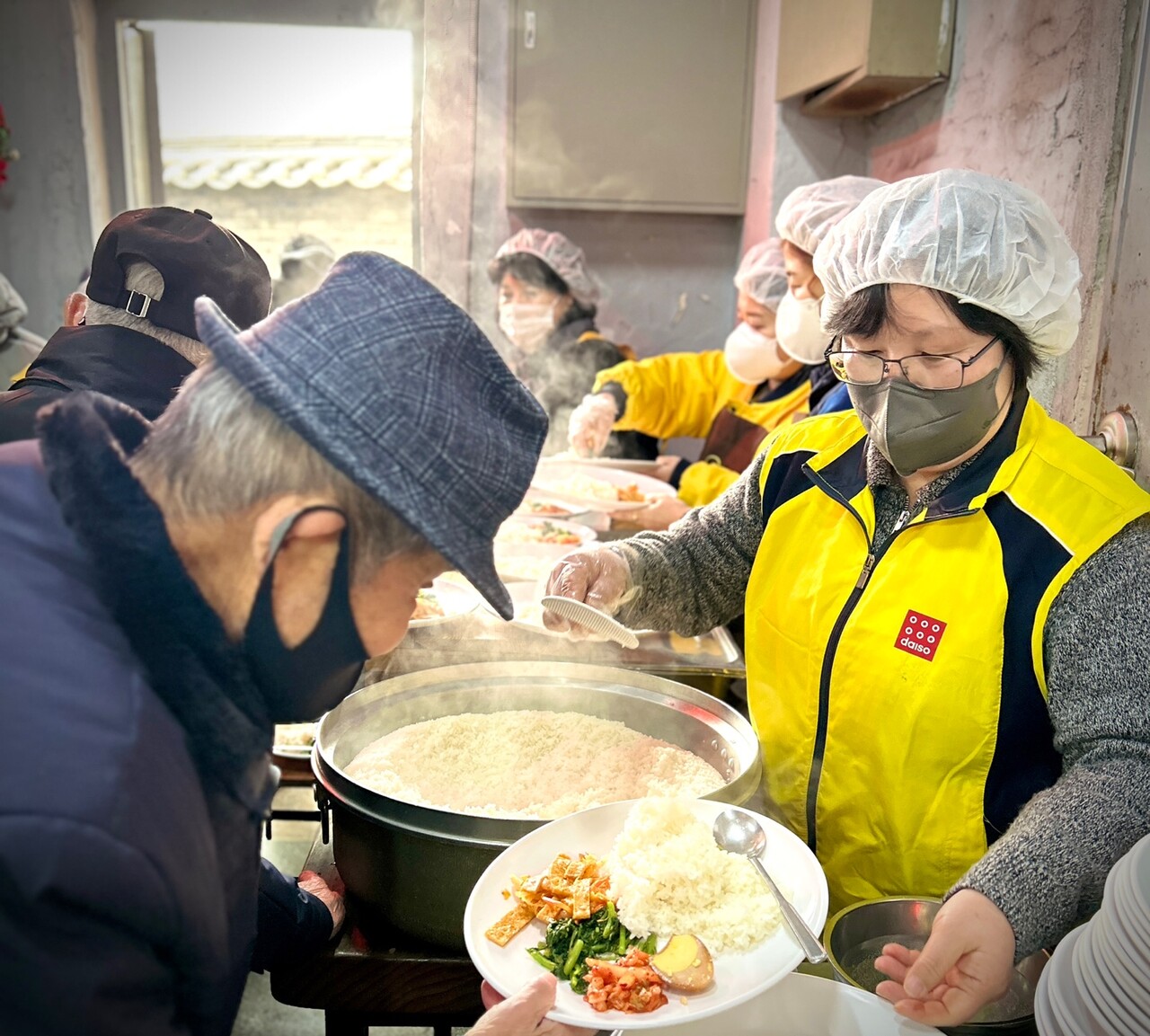 아성다이소 임직원들이 지난 21일 사회복지원각 무료 급식소에서 노인과 노숙인들을 대상으로 제공하는 무료 점심을 배식하고 있다. (출처=아성다이소)