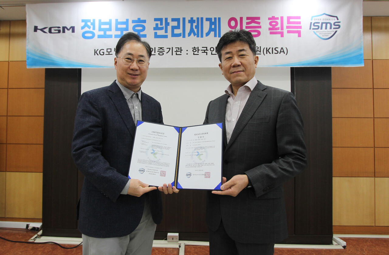 KG 모빌리티가 한국인터넷진흥원의 정보보호 관리체계(ISMS) 인증을 획득하고 기념촬영 하고 있다. 황기영 KGM 대표이사(오른쪽)와 전승재 경영지원본부장 (출처=KGM)