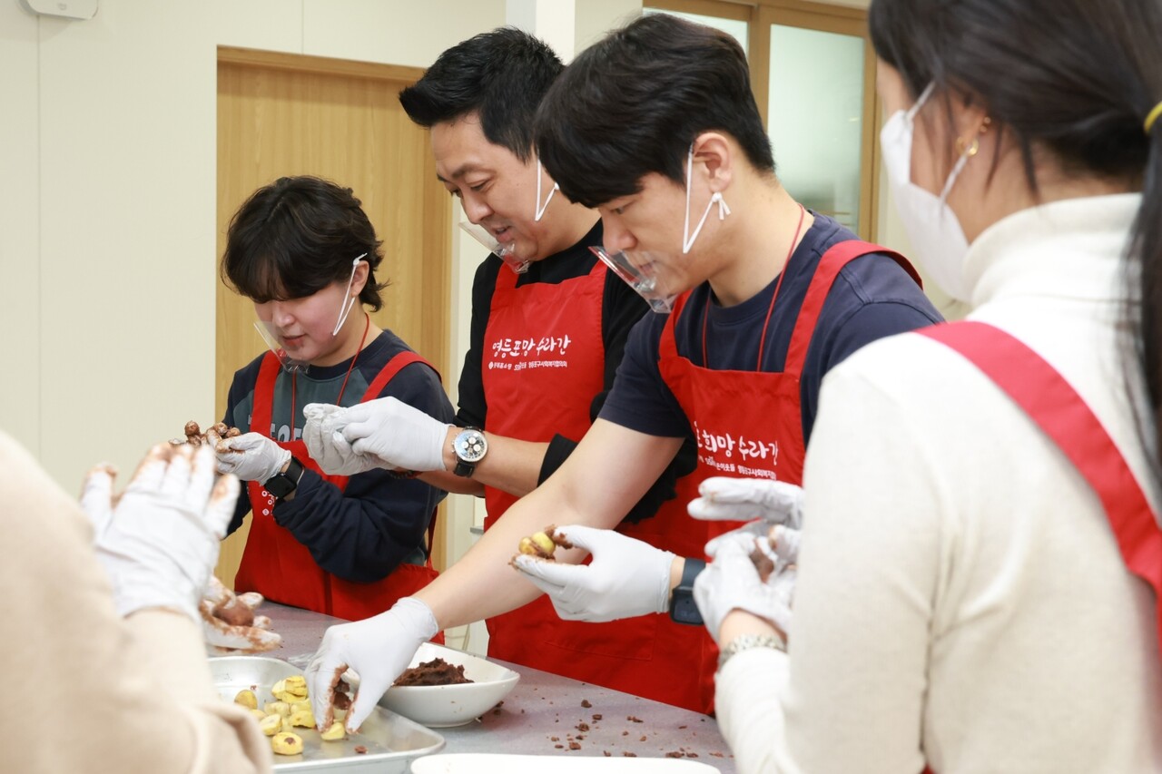 'TEAM 나눔런치'에 참여한 임직원들이 영등포지역 독거 어르신에게 전달할 공주 밤 찹쌀떡을 만들고 있다. (출처=롯데홈쇼핑)